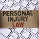 Conceptual hand writing showing Personal Injury Law. Business photo showcasing guarantee your rights in case of hazards or risks written Folded Cardboard Paper Piece placed Keyboard.