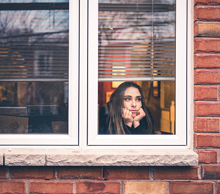 A woman looking desperate lookingat the window