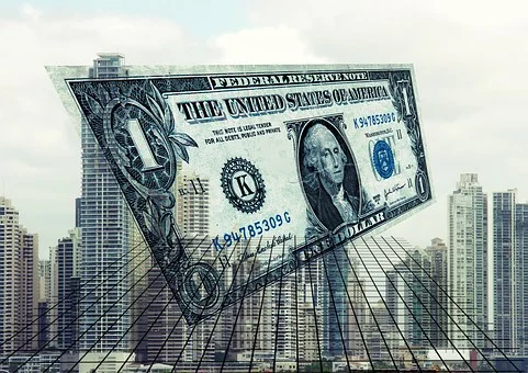 A hanging dollar bill with buildings on the back