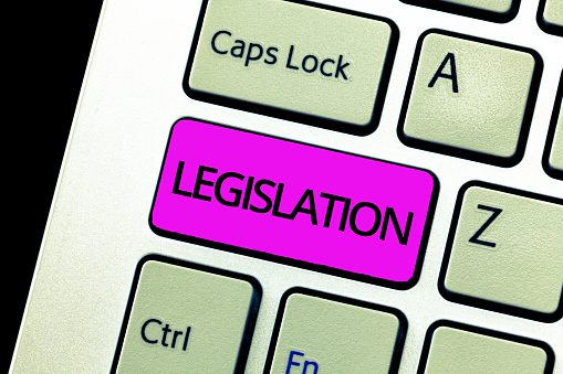 A computer keyboard with legislation written on one of it in purple colour