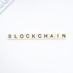 Blockchain written with Scrabble pieces on a white background