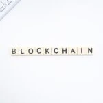 Blockchain written with Scrabble pieces on a white background